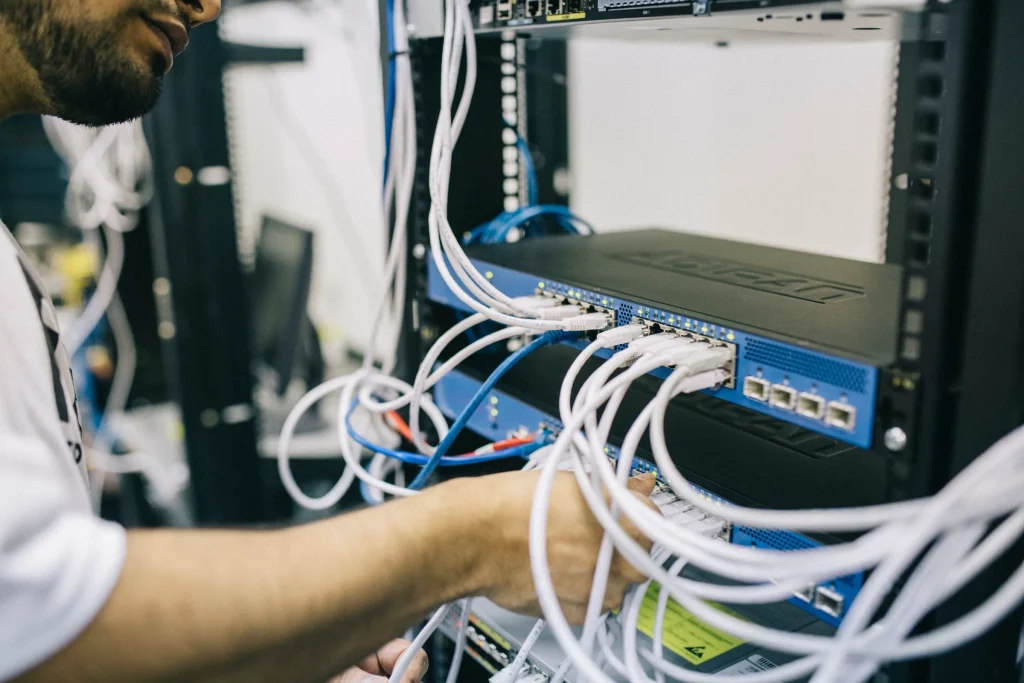 Técnico a configurar cabos num bastidor de rede