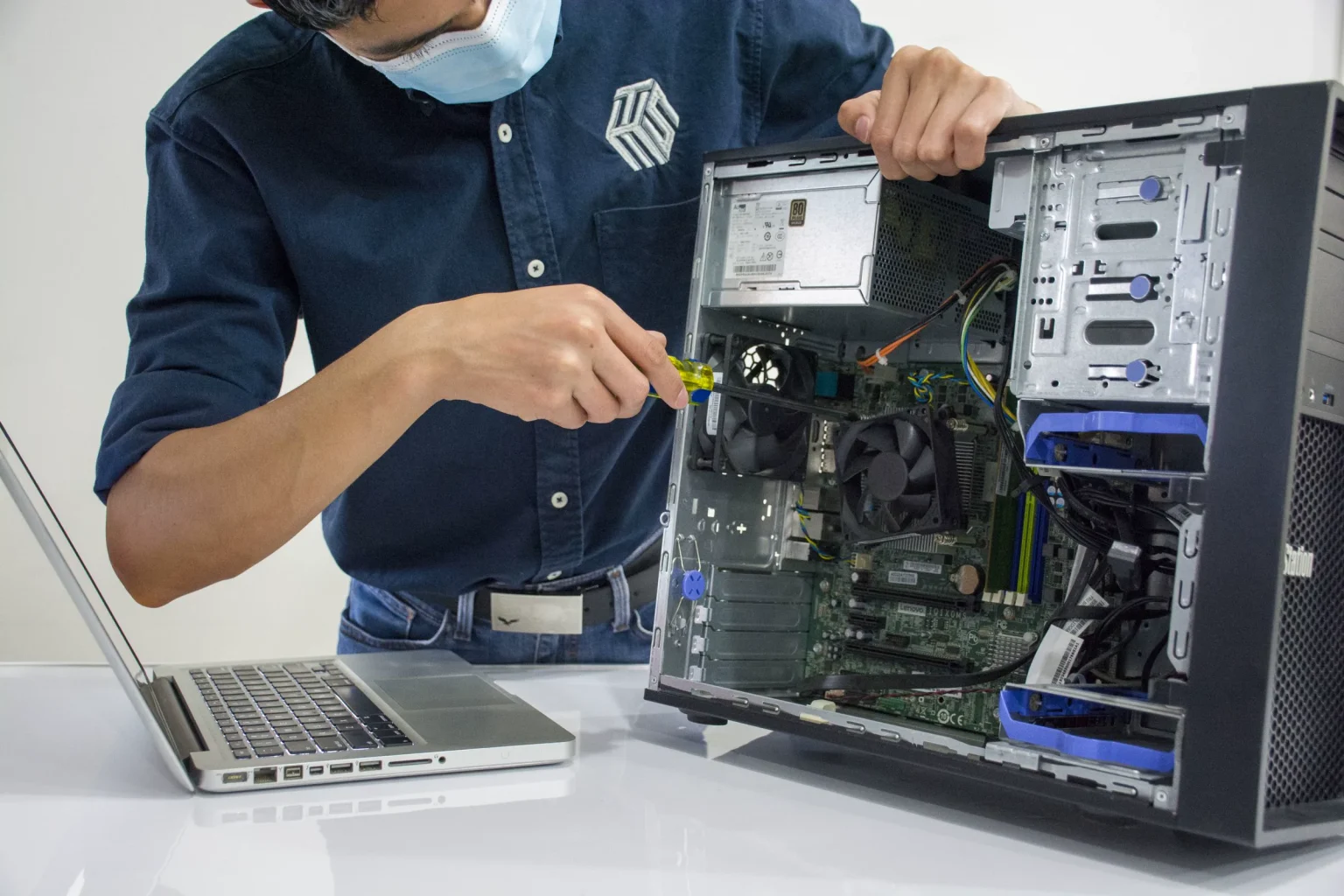 Técnico a reparar um computador de secretária aberto